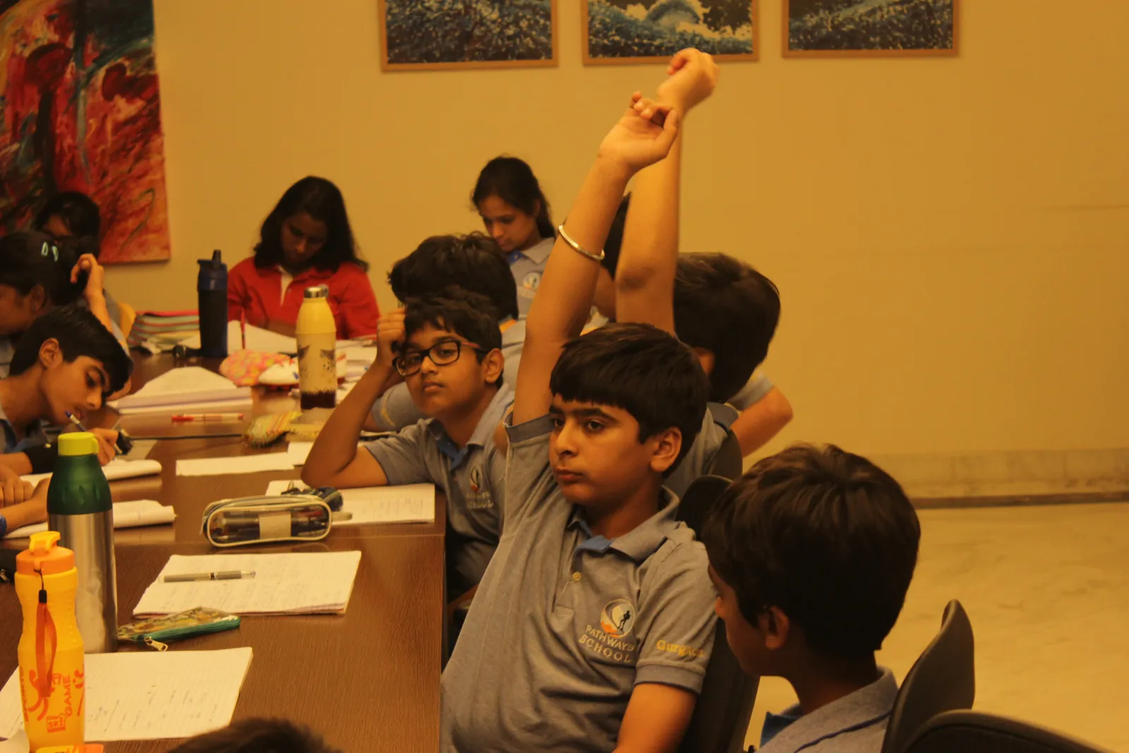 Children raising their hands to answer in a Brainwiz workshop