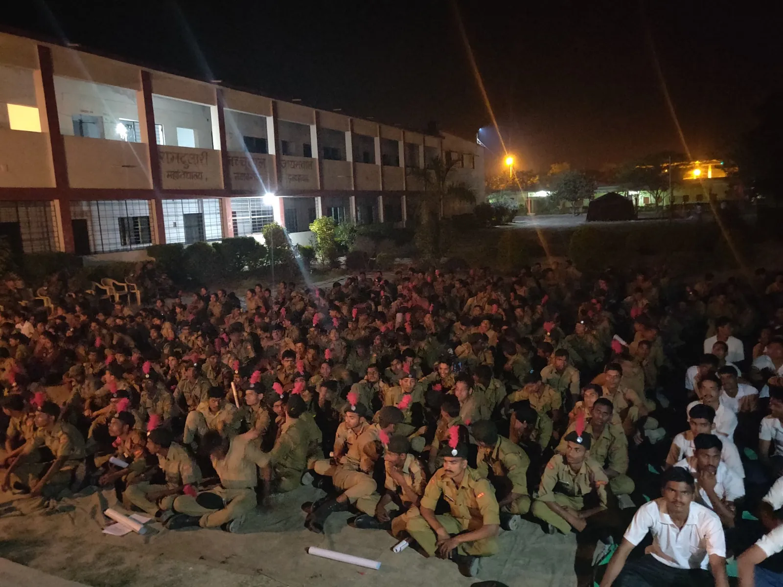 NCC cadets seated on the ground at night during the marathon