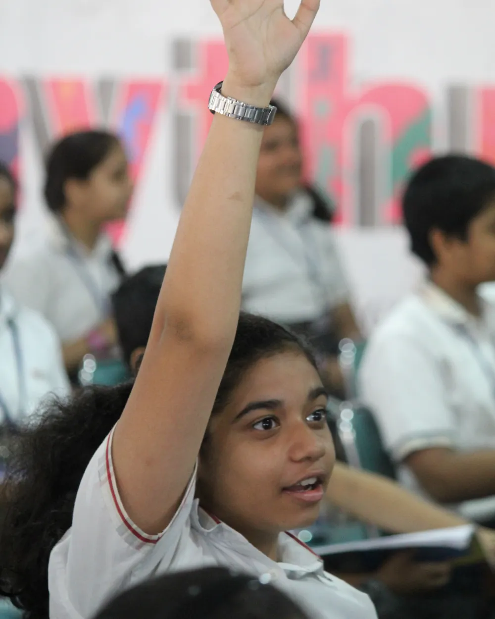 A student raising her hand to ask a question in class