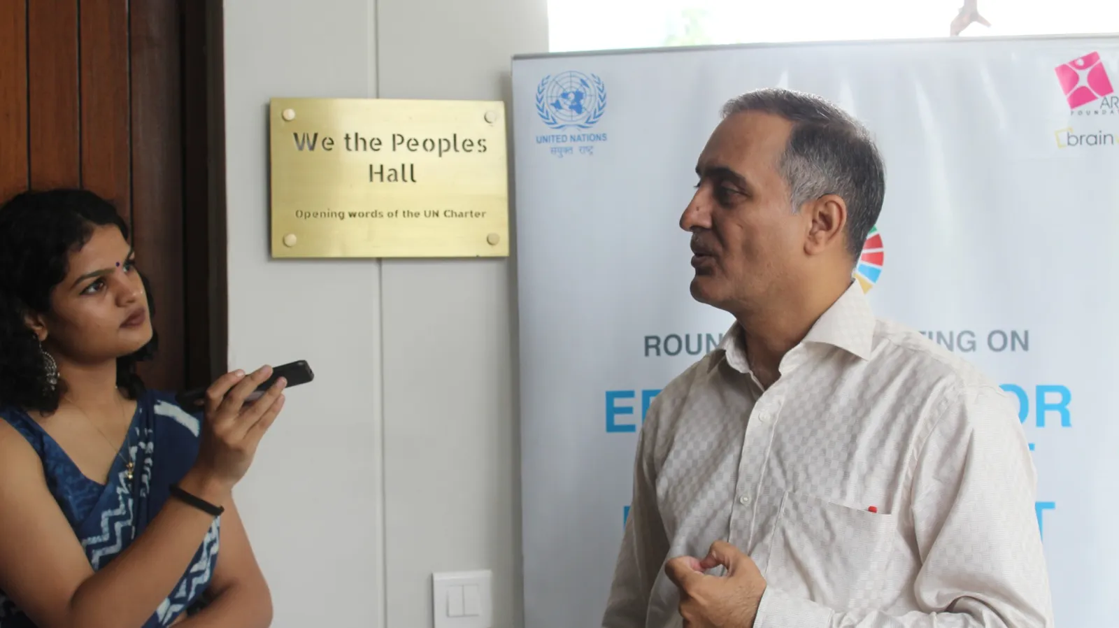 A Brainwiz team member interviewing a participant outside We the Peoples Hall, UN House